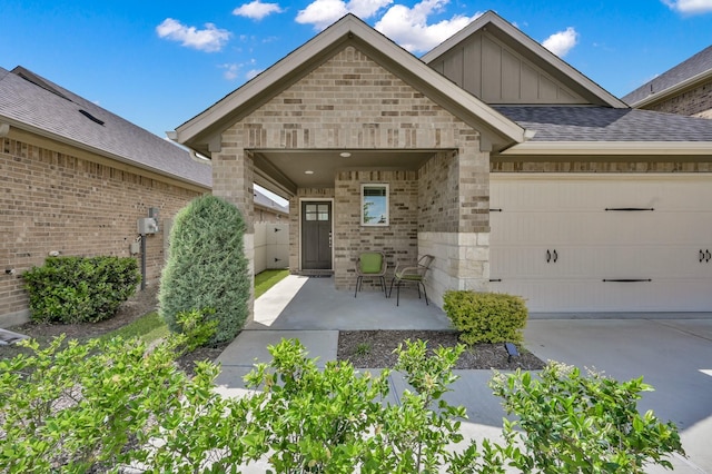 17422 Buckeye Br, Conroe, TX 77385 - doorway to property featuring board and batten siding, brick siding, a garage, and concrete driveway