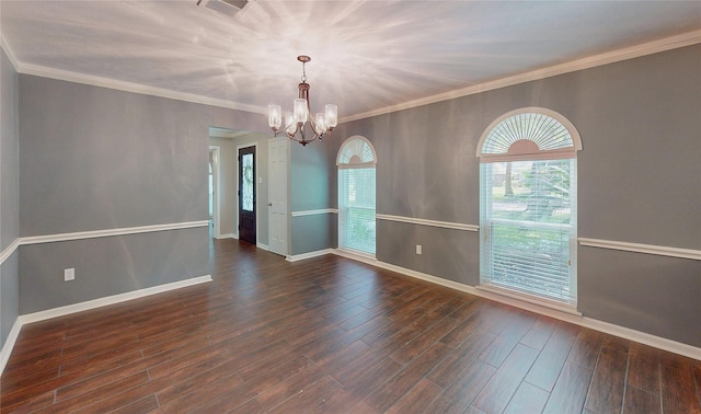 spare room with an inviting chandelier, baseboards, wood finished floors, visible vents, and ornamental molding