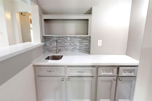 bar with a sink and tasteful backsplash