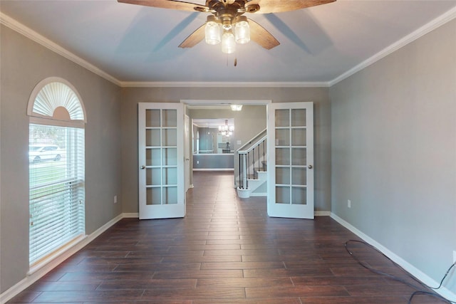 empty room with french doors, ornamental molding, dark wood finished floors, and stairway