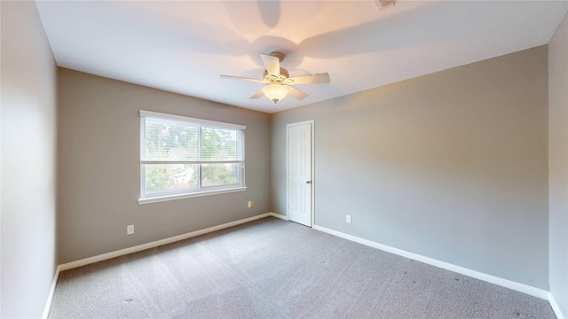 carpeted empty room featuring baseboards and ceiling fan