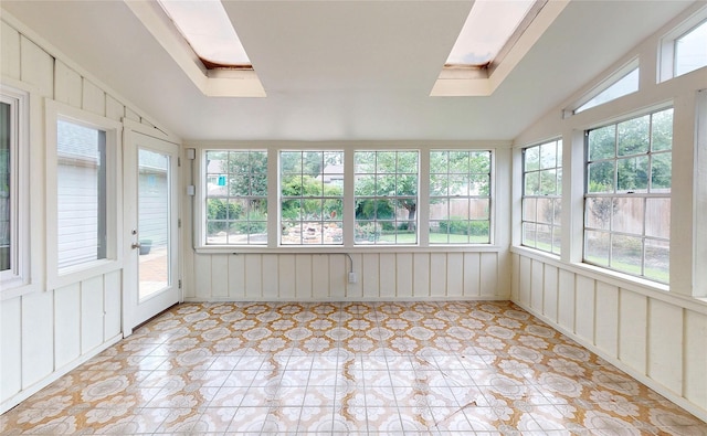 unfurnished sunroom featuring lofted ceiling with skylight