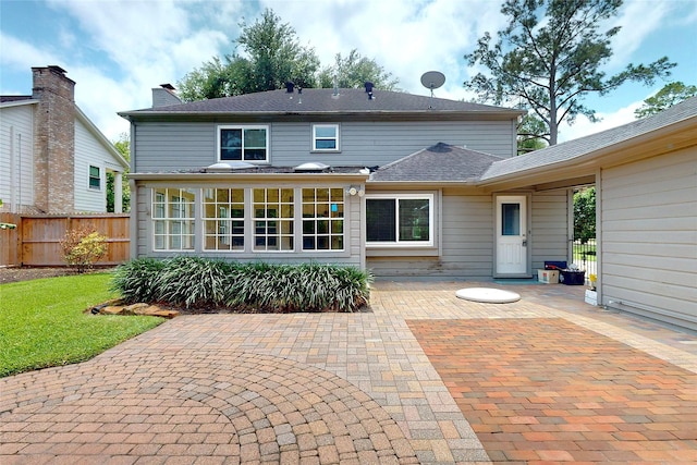 rear view of property featuring fence and a patio