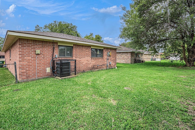 12719 Panay Dr, Houston, TX 77048 - back of house featuring a lawn, fence, central air condition unit, and brick siding