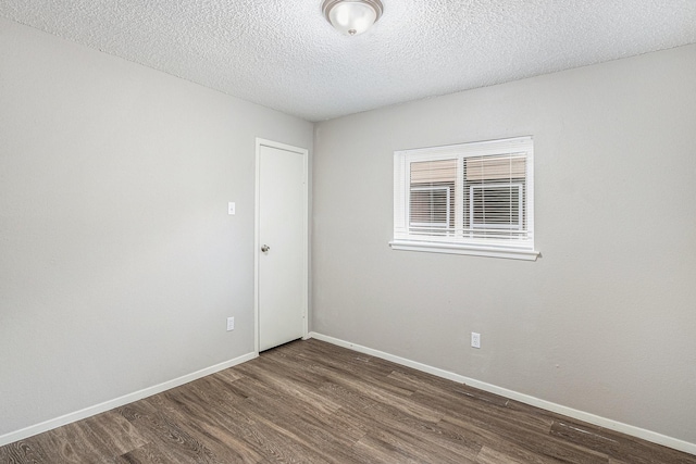12719 Panay Dr, Houston, TX 77048 - empty room featuring baseboards, dark wood finished floors, and a textured ceiling