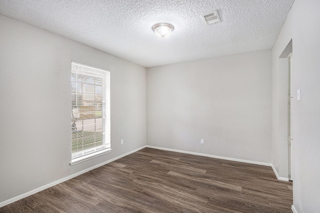 12719 Panay Dr, Houston, TX 77048 - unfurnished room with dark wood-style flooring, a textured ceiling, visible vents, and baseboards