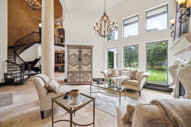 living area featuring a fireplace, a chandelier, stone tile floors, a towering ceiling, and stairway