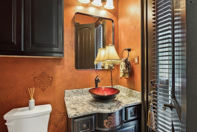 half bathroom featuring vanity and toilet