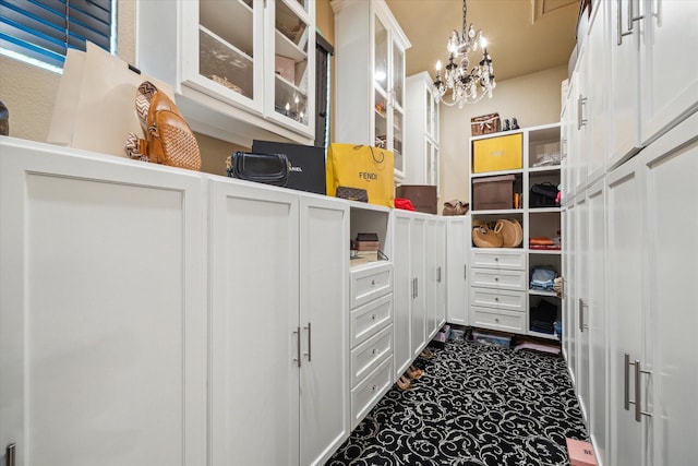 walk in closet with an inviting chandelier