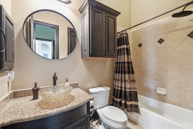 bathroom featuring vanity, a textured wall, shower / bath combination with curtain, and toilet