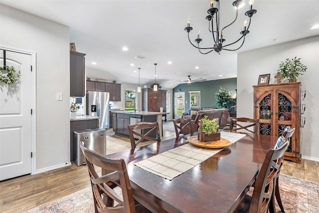 dining space with ceiling fan with notable chandelier, recessed lighting, and light wood-style flooring