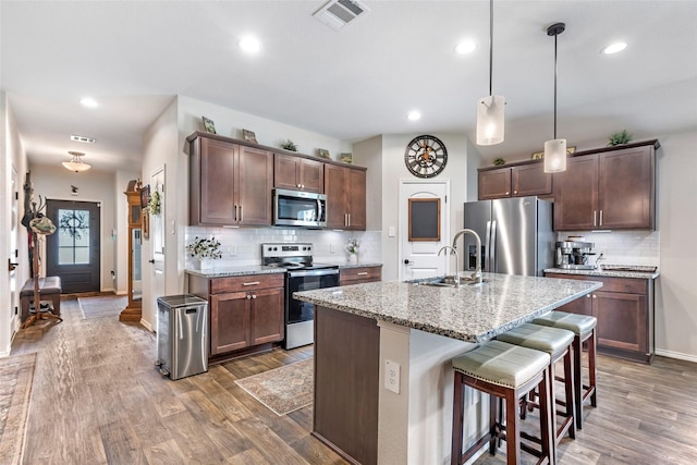 kitchen featuring visible vents, a sink, appliances with stainless steel finishes, and wood finished floors