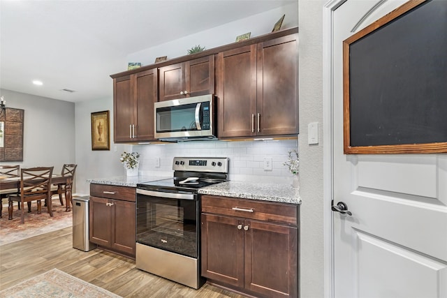 kitchen featuring decorative backsplash, dark brown cabinetry, light stone countertops, light wood-style floors, and stainless steel appliances