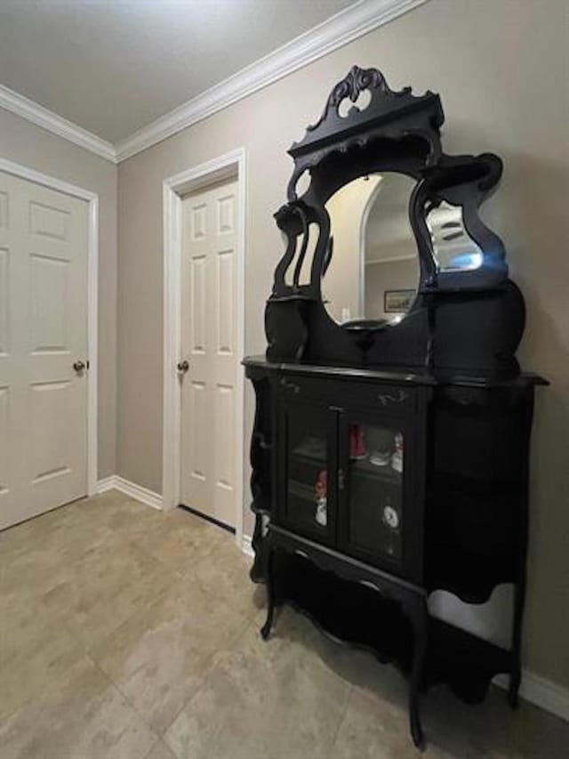 interior space with crown molding and baseboards