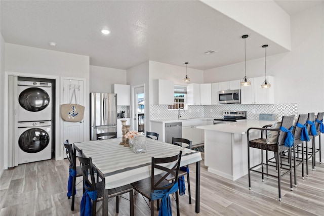 dining room featuring stacked washing maching and dryer, recessed lighting, light wood finished floors, and visible vents