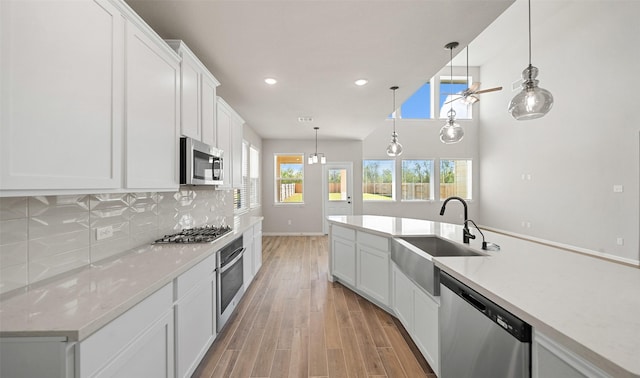 2617 Bisbee Rd, League City, TX 77573 - kitchen with appliances with stainless steel finishes, a sink, tasteful backsplash, light wood-style flooring, and recessed lighting
