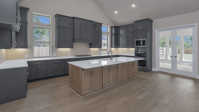 12944 Whitewater Way, Conroe, TX 77302 - kitchen with stainless steel appliances, light wood-type flooring, light countertops, tasteful backsplash, and high vaulted ceiling