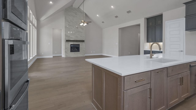 12944 Whitewater Way, Conroe, TX 77302 - kitchen with ceiling fan, oven, beamed ceiling, light wood-type flooring, and light countertops