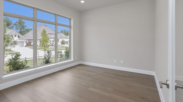 12944 Whitewater Way, Conroe, TX 77302 - empty room featuring plenty of natural light, dark wood-style floors, recessed lighting, and a residential view