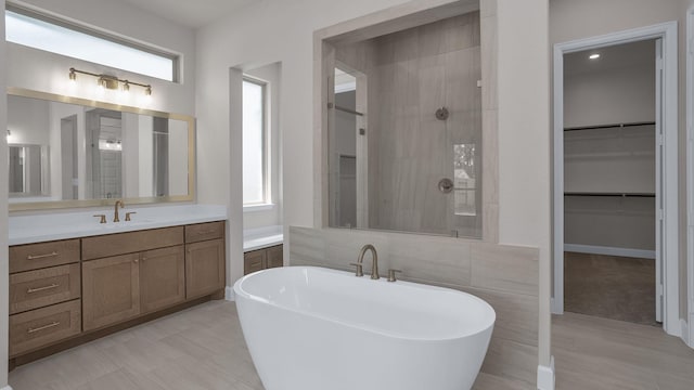 12944 Whitewater Way, Conroe, TX 77302 - full bathroom with a freestanding bath, vanity, healthy amount of natural light, and tile walls