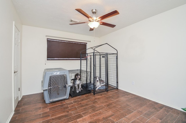 interior space with baseboards, ceiling fan, wood finished floors, and visible vents