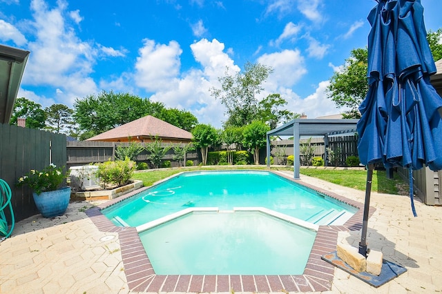 view of swimming pool with a gazebo, a pool with connected hot tub, a fenced backyard, and a patio area