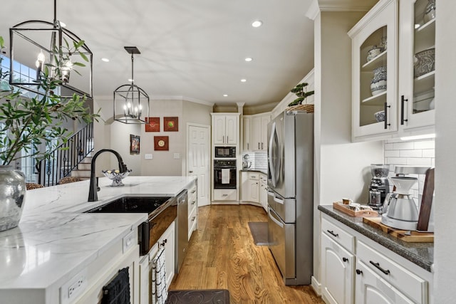 kitchen with crown molding, a chandelier, recessed lighting, light wood-type flooring, and black appliances