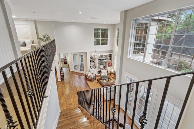 staircase with an inviting chandelier, baseboards, recessed lighting, and wood finished floors