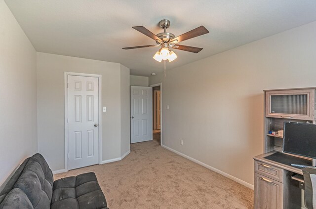 living area featuring light colored carpet, baseboards, and ceiling fan