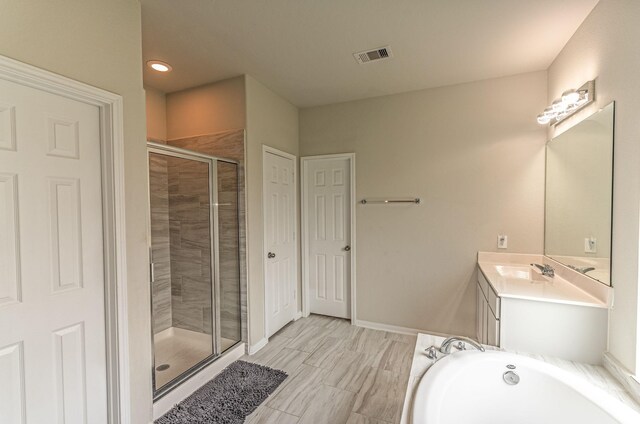 full bathroom featuring a bath, visible vents, a shower stall, vanity, and baseboards