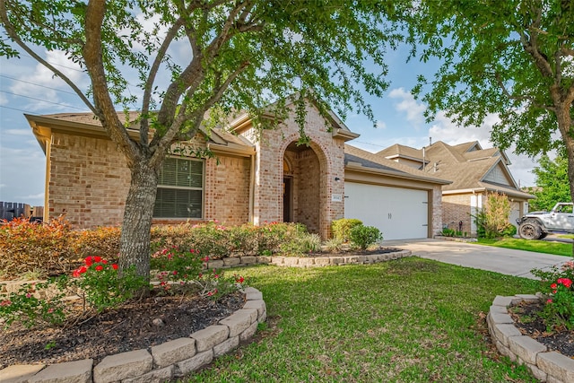 view of front of property with an attached garage, concrete driveway, a front lawn, and brick siding