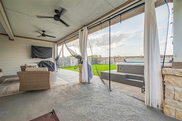 sunroom featuring plenty of natural light, ceiling fan, and a hot tub