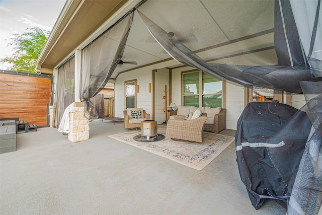 view of patio with an outdoor living space, a ceiling fan, and fence