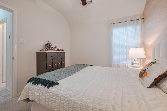 bedroom with a ceiling fan, visible vents, carpet, and lofted ceiling