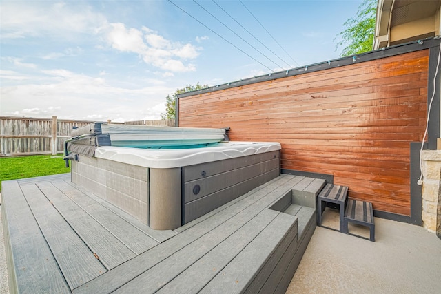 wooden deck featuring a hot tub and fence