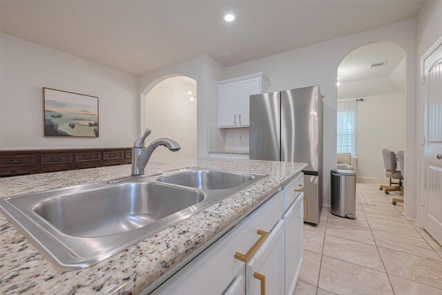 kitchen featuring visible vents, arched walkways, a sink, recessed lighting, and white cabinetry