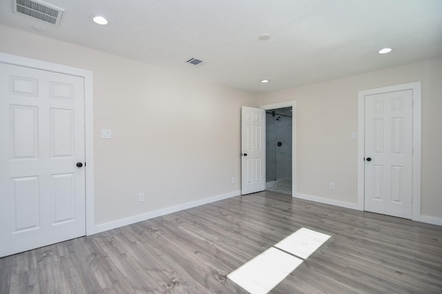 unfurnished bedroom with baseboards, recessed lighting, wood finished floors, and visible vents