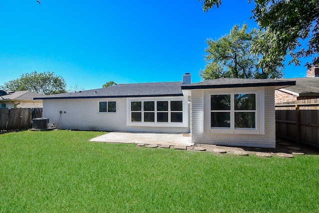 rear view of house with a patio, a fenced backyard, a yard, and brick siding