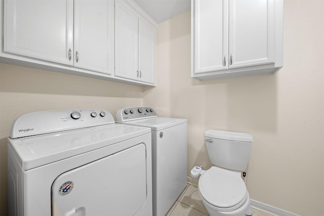 laundry room featuring light tile patterned floors, separate washer and dryer, baseboards, and laundry area