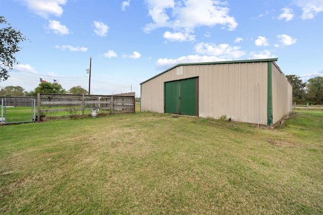 view of pole building with fence and a yard