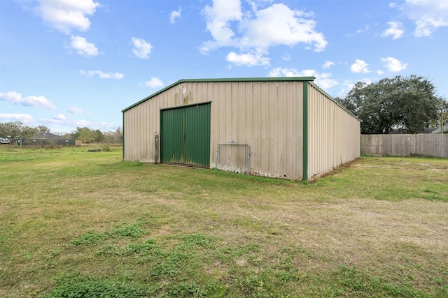 view of pole building featuring a lawn and fence