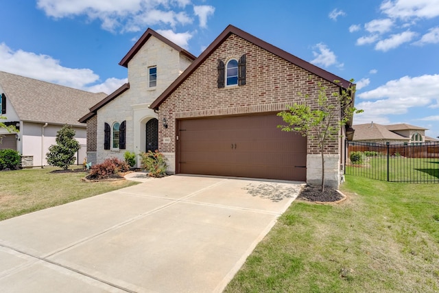 french provincial home featuring a front yard, brick siding, fence, concrete driveway, and stone siding