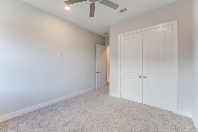 unfurnished bedroom featuring carpet, a ceiling fan, baseboards, visible vents, and a closet