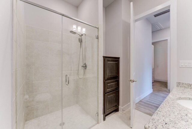full bathroom with vanity, a stall shower, and visible vents