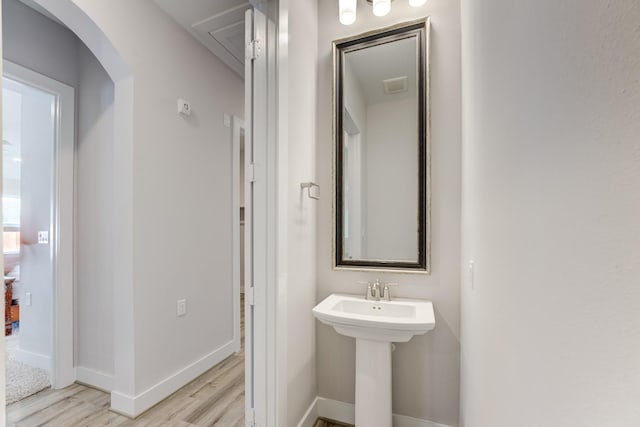 bathroom featuring a sink, baseboards, visible vents, and wood finished floors