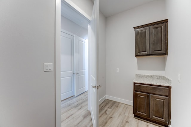 hall with baseboards and light wood-style flooring