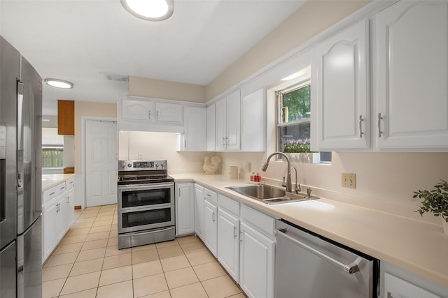 711 Rosewood Dr, Shenandoah, TX 77381 - kitchen with stainless steel appliances, a sink, white cabinetry, and healthy amount of natural light