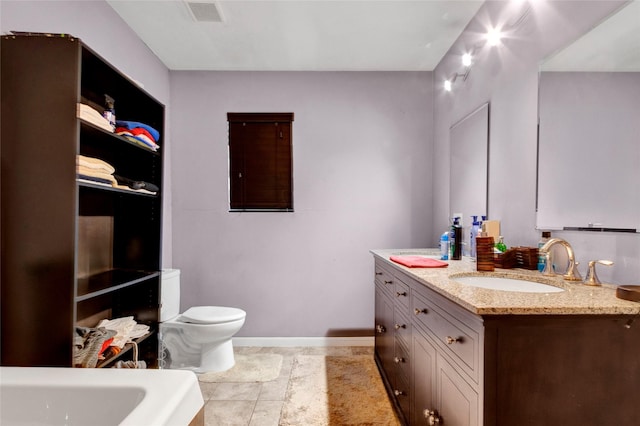 bathroom with vanity, toilet, baseboards, visible vents, and a bath