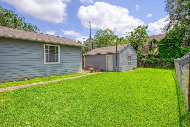 view of yard with fence and an outdoor structure