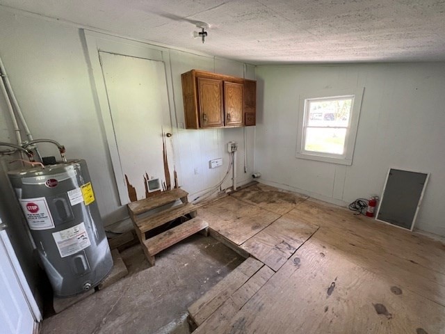 clothes washing area with cabinet space and water heater